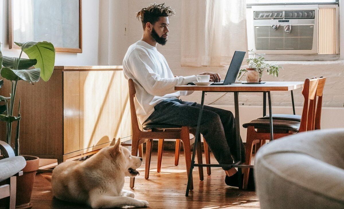 Mann konzentriert am Tisch sitzend bei einer Workation im Ausland