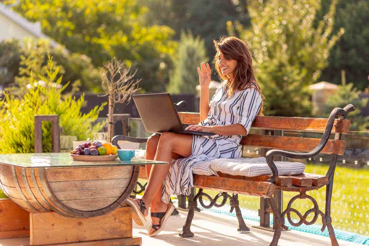 Frau mit einem Videoanruf mit Laptop draußen